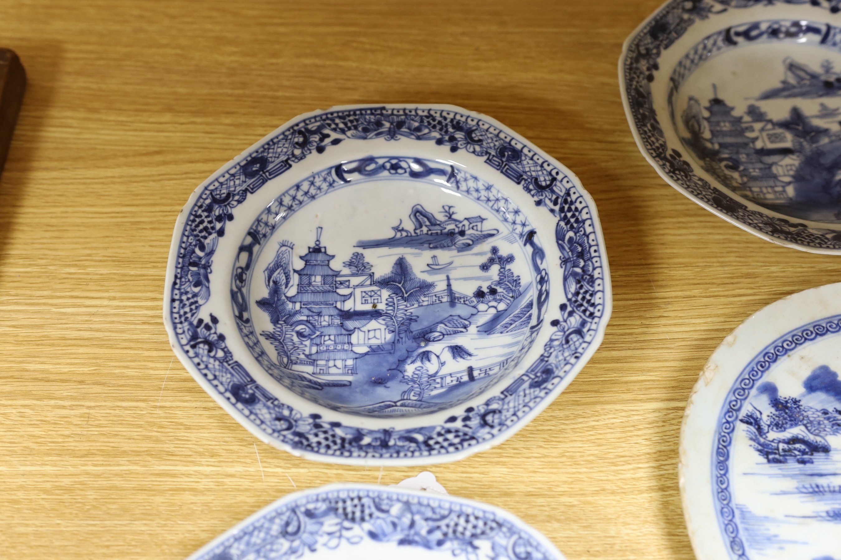 A selection of severn 18th century Chinese export blue and white dishes, largest 35cm wide